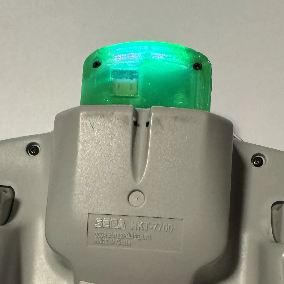 Close-up of the adapter in the expansion bay, its status LED lighting the translucent shell green