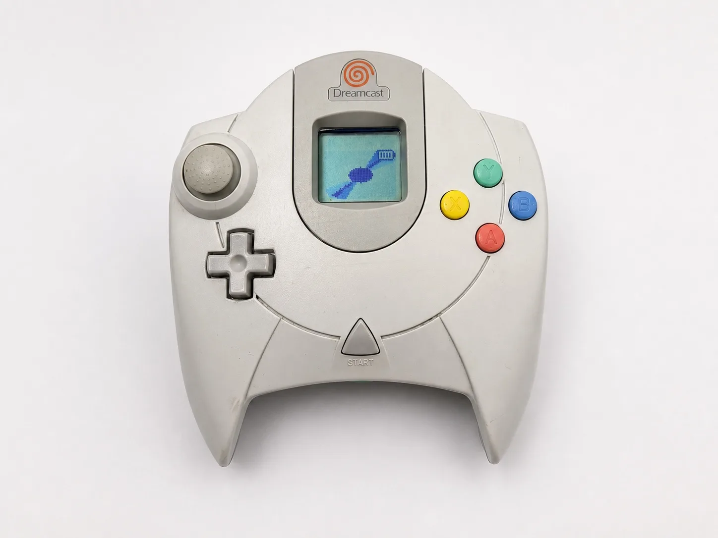 Dreamcast controller face up with the VMU screen lit